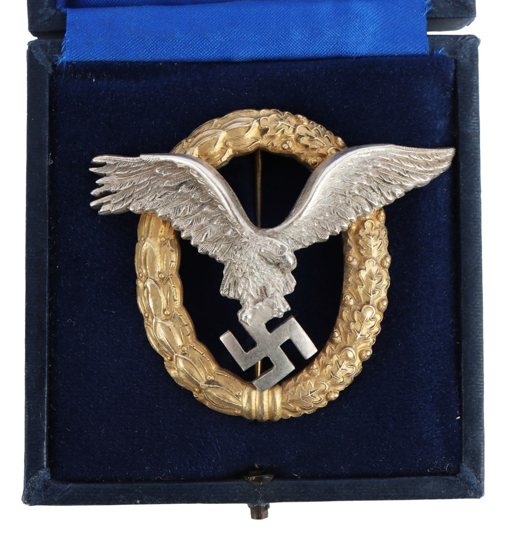 WWII GERMAN LUFTWAFFE COMBINED PILOT BADGE: Combined Pilot/Observer badge. Eagle in the center clutching swastika surrounded by oak and laurel leaf wreath. C.E. Juncker marked. It measures 2 1/8 inches. Tombac construction with gilt finish.