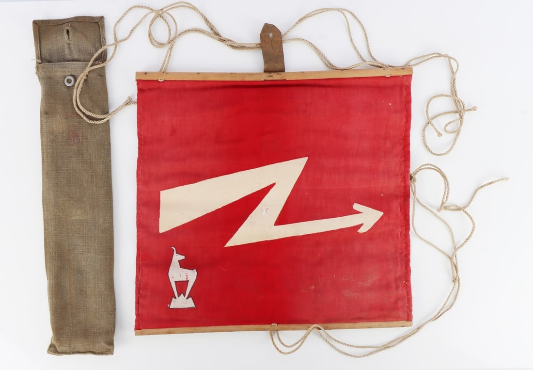 WEHRMACHT 5TH MOUNTAIN DIV BLITZFLAGGE SIGNAL FLAG: Wehrmacht signal flag, or lightning flag, of red linen. Painted on both sides with a lightning bolt arrow and the gamskitz goat insignia of the 5th Gebirgsjager division. Wood dowel hoists top and