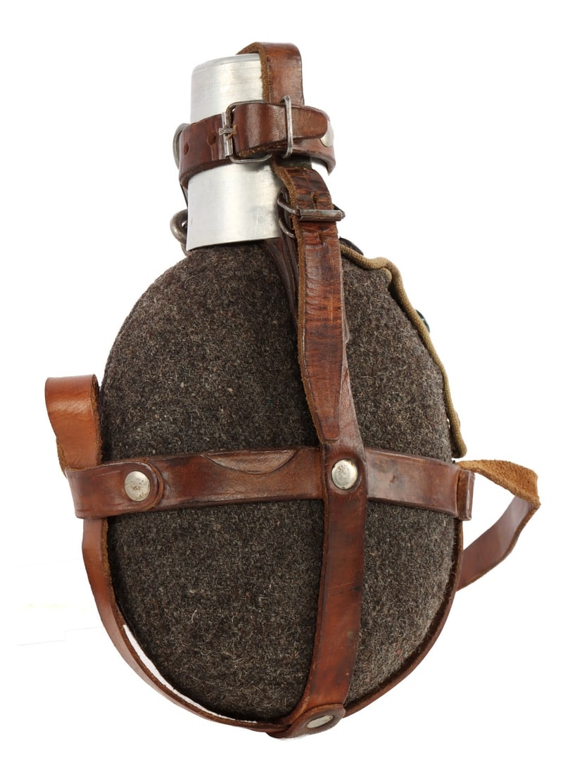 INTERWAR YUGOSLAVIAN CANTEEN WITH COVER & CUP: A Yugoslavian canteen produced between the First and Second World Wars. With strap, cup, and cover. Screw top intact. Approximately 6 by 8 inches. A remarkably intact example, near mint.