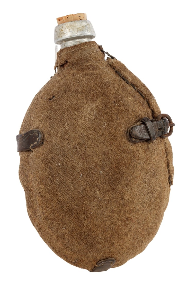 WWI IMPERIAL RUSSIAN CANTEEN WITH COVER: A WWI imperial Russian canteen with cloth cover. The presence of an extant cover for a Russian imperial canteen is rare. Imperial markings on spout. 5 X 8 inches. No stopper. Some wear.