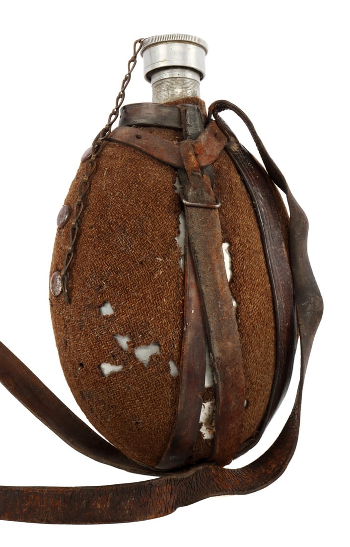 WWII BULGARIAN ROYAL ARMY CANTEEN: A WWII-era canteen from Bulgaria, with the Bulgarian royal lion on the screw cap;. Cloth cover, screw cap, and leather hanger/strap are intact. This is a particularly rare variant of the Bulgarian Arm