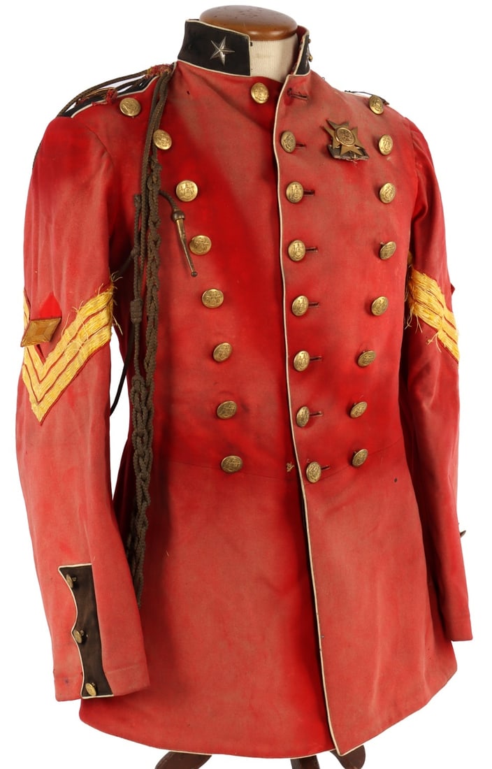 NEW YORK MILITIA ARTILLERY OFFICER'S DRESS JACKET: New York Militia officer's triple-breasted dress jacket of red wool, ca. 1870s. Bears insignia of a first sergeant, Battery B, 3rd New York Artillery. Right shoulder has aiguilette of braided metallic