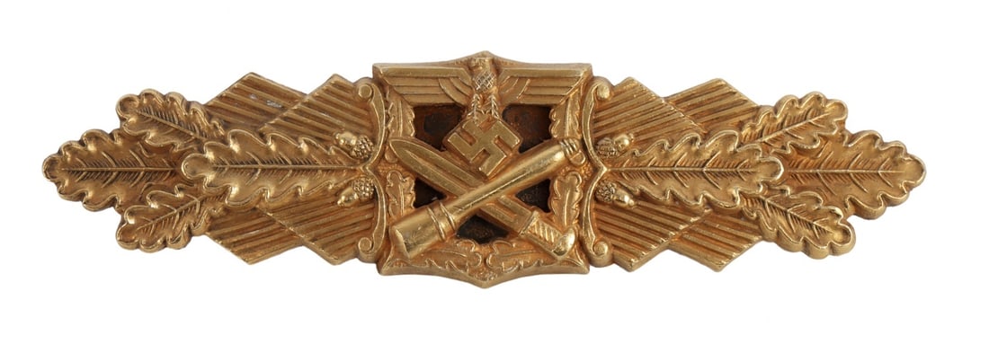 WWII GERMAN CLOSE COMBAT CLASP GOLD: WWII German Third Reich close combat spange. Crossing bayonet and stick grenade, oak leaf pattern with intact gilding. Reverse is correctly unmarked. Measures 3.75 L x 1 H inches. This lot has a reser