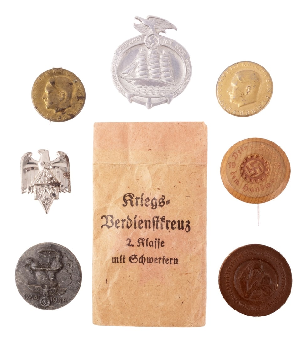 WWII GERMAN REICH COLLECTION OF TINNIES LOT OF 8: A collection of eight small items from the German Third Reich. Five tinnies, two wooden badges, and an envelope for a war merit cross.