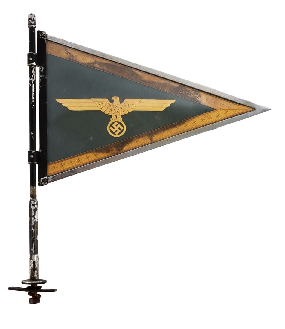WWII GERMAN THIRD REICH HEER GENERALS PENNANT: A vehicle pennant for a general staff officer of the Heer of the German Third Reich. Gold cloth Reichsadler and swastika on a dark blue background, flanked by swastika ribbons. 15 X 10 inches. | | | |
