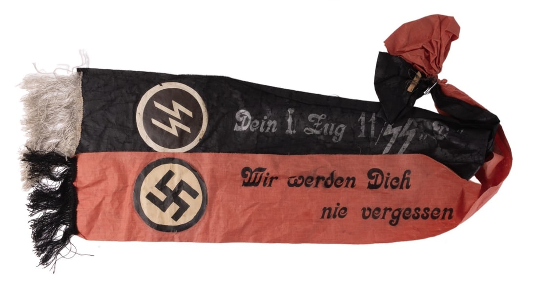 WWII GERMAN THIRD REICH SS FUNERAL SASH: A black and red funeral sash for a member of the SS. The black banner reads "Dein I. Eug 11/SS "D"" while the red reads "Wer Werden Dich nie Vergessen." 50 inches long, approximately 7.1 inches wide.