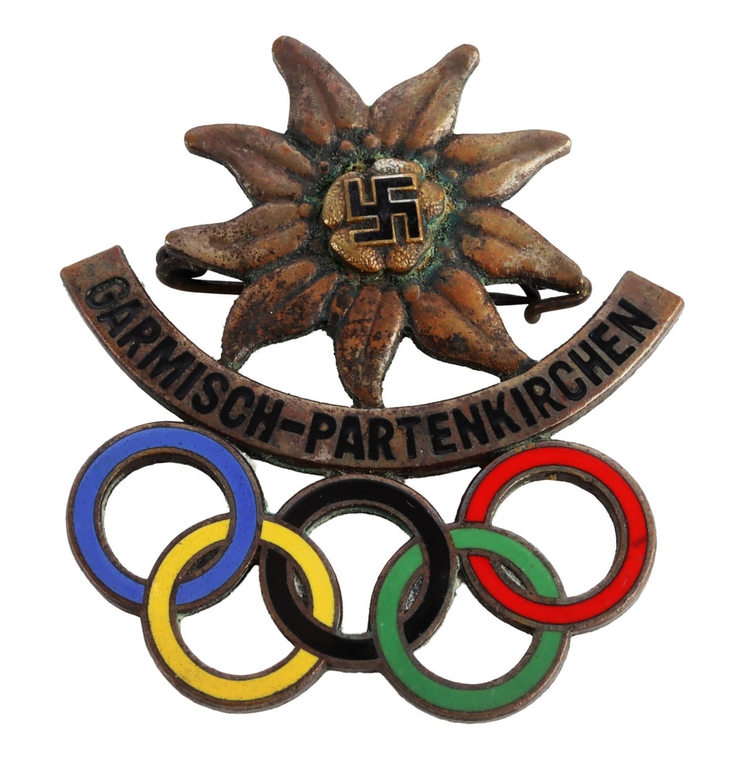 1936 WWII THIRD REICH GERMAN WINTER OLYMPICS PIN: Third Reich pin from the 1936 Winter Olympic games held in Garmisch-Partenkirchen. Marked ' Annetsberger Munchen ' on reverse. Enamel Olympic rings. Edelweiss with swastika design. Unauthenticated. So