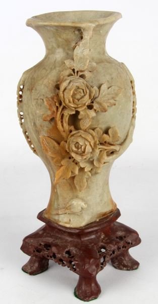 CHINESE CARVED SOAPSTONE VASE: Vase measures approximately 12 inches in height. Has a deeply carved floral motif with peony flowers and a small bird carved into the front. Vase is affixed to a porphyry-colored soapstone base. Some 