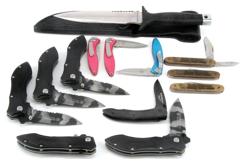 13 SMITH & WESSON KNIVES CK2CMS SWLF1 CK107BL: Grouping consists of five CK2CMS Serrated Drop Point Knives with camo blade, two CK107RD cutting horse red 5.75 knives, one SWLF1 little folder knife, one CK107BL cutting horse blue 5.75 inches knife,