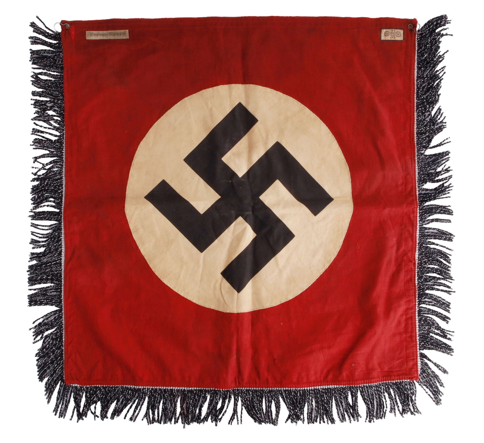WWII GROSS ROSEN CONCENTRATION CAMP BANNER: A WWII German Third Reich concentration camp Gross Rosen trumpet banner. Cotton construction with sewn on roundel. The front shows a swastika insignia. The bottom and sides feature a fringe. Marked wi