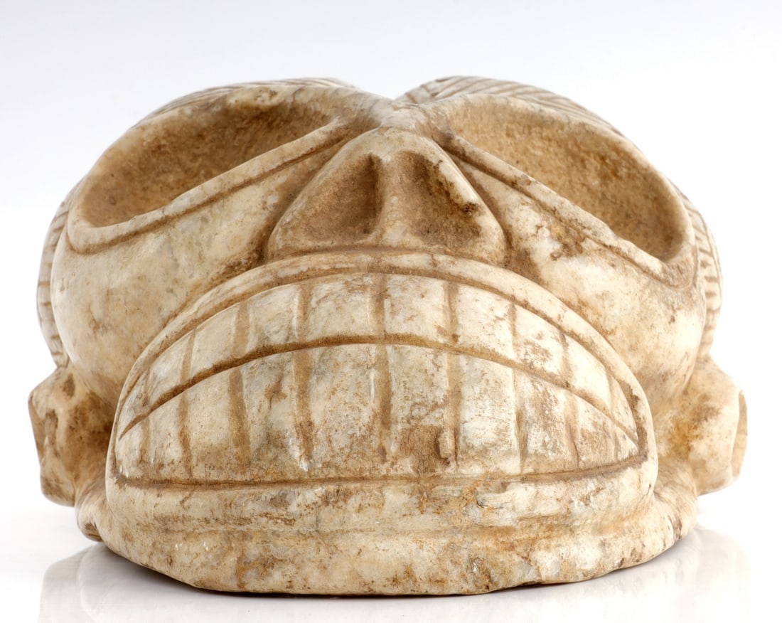 Rare Engraved Taino Portrait: Taino. Skull with bifurcated cranium an extremely rare form of skull modification. Exhibiting hour glass eyes and mouth margins, both common Taino design elements. A large mouth with a huge dental dis