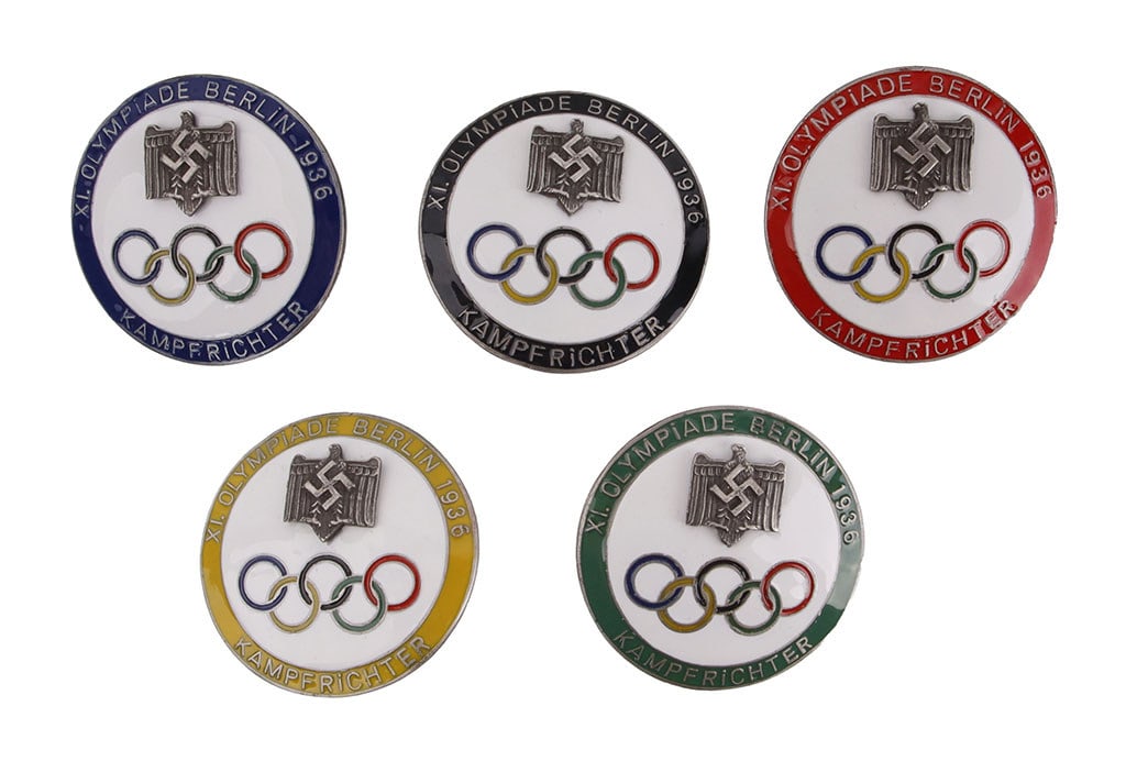 5 Olympic Badges WWII German Reich: A set of five (5) judge badges from the 1936 Berlin Olympics, with colored rings corresponding to the colors of the Olympic colors. Features a swastika and Reichsadler.