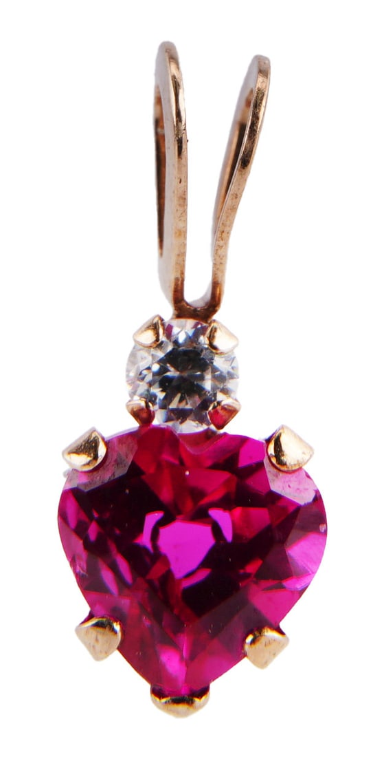 Ruby Heart Pendant 10K Yellow Gold: Heart shaped ruby pendant 10K yellow gold. Stamped 10K on inside of loop. Ruby is 4.96x4.84mm. Accent CZ stone above ruby. Pendant measures 0.46x0.19x0.13 inches. | This lot has a reserve.