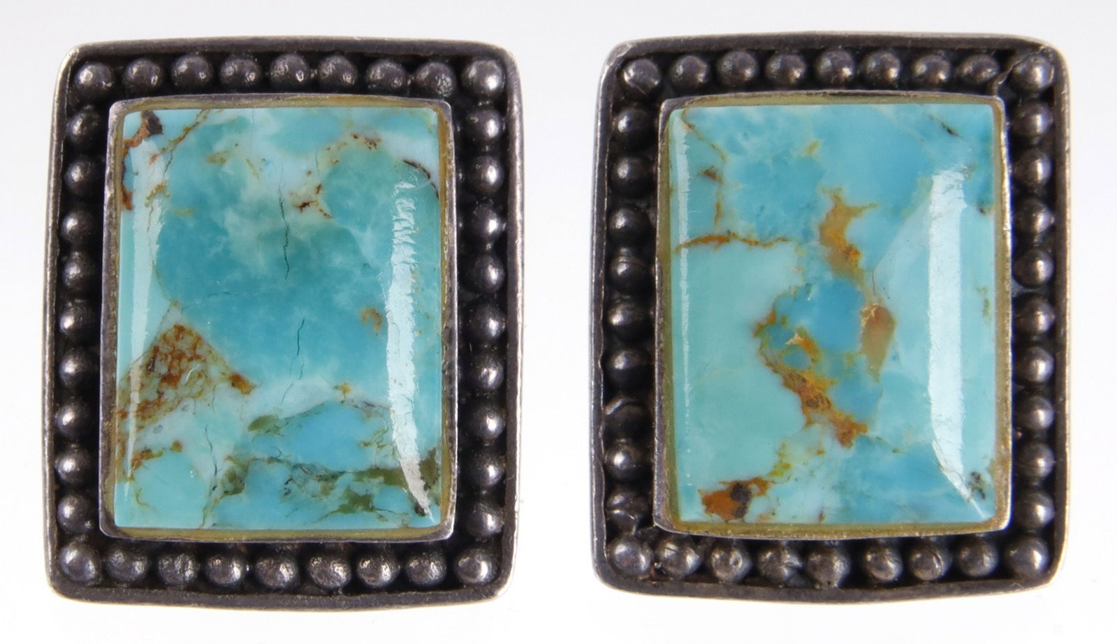 Hachita Turquoise Earrings Sterling Silver: Western sterling silver earrings made with Hachita turquoise. Stones are 13.46x10.33 mm. Earring measure 0.72x0.60 inches. Stamped "925" on reverse. | This lot has a reserve.