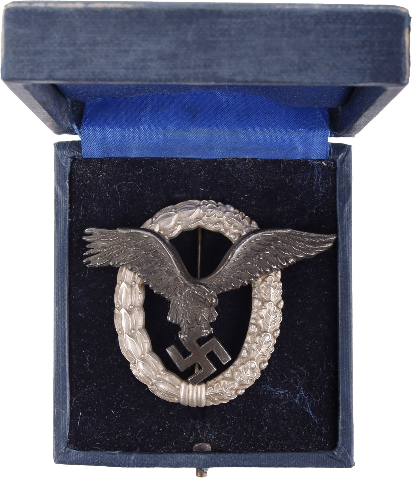 Cased Luftwaffe Pilot Badge WWII German: WWII German Luftwaffe Pilot badge. Silver toned laurel and oak leaf wreath with blackened eagle. It measures 2 inches. C. E. Juncker make. Cased titled Luftwaffen Flugzeugfuhrer Abzeichen | This lot h