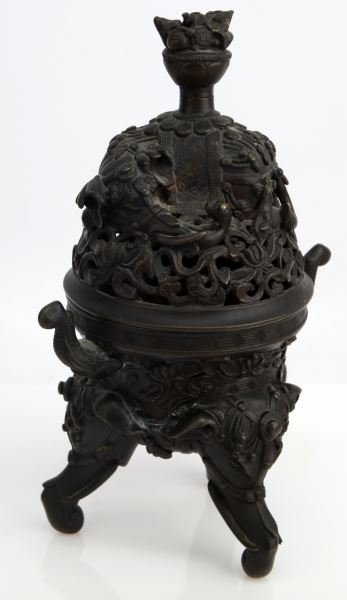 INDIAN BRONZE INCENSE BURNER EARLY 20TH CENTURY: Early 20th century Indian cast bronze incense burner. Bell shaped, open scrollwork design lid with ornately dressed elephant lying down. Two elephant trunk handles (one loose). Tripod bottom, elephant