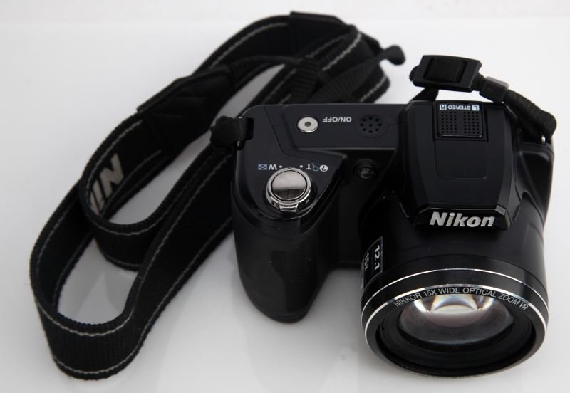NIKON COOLPIX L110 DIGITAL CAMERA 5-75MM LENS: Digital camera features a Nikkor 15x wide optical zoom lens. LCD screen has light scratches only visible while camera is powered down. Tested and in working condition.