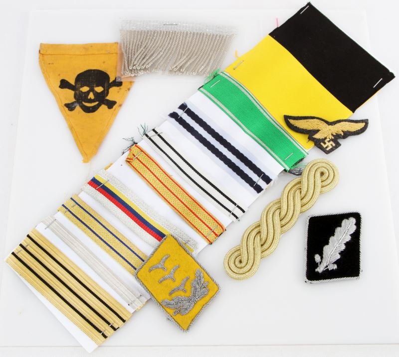 MISCELLANEOUS WWII GERMAN TUNIC INSIGNIA & REPRO: Miscellaneous grouping of WWII German tunic accoutrements. includes spurious SS and Luftwaffe insignia, small death skull pennant, and reproduction ribbons. All in very good condition.