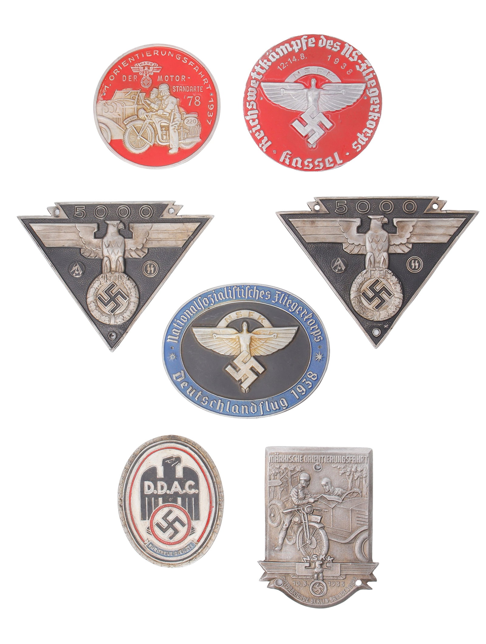 WWII German Motor Rally Badges Lot of 7: One tin badge NSKK Motor Rally plaque. Silver depicting motorcyclist and auto driver conversing. Three holes for attachement.4" x3". One DDAC (Deutscher Auto Club) badge. White oval depicting SS eagle