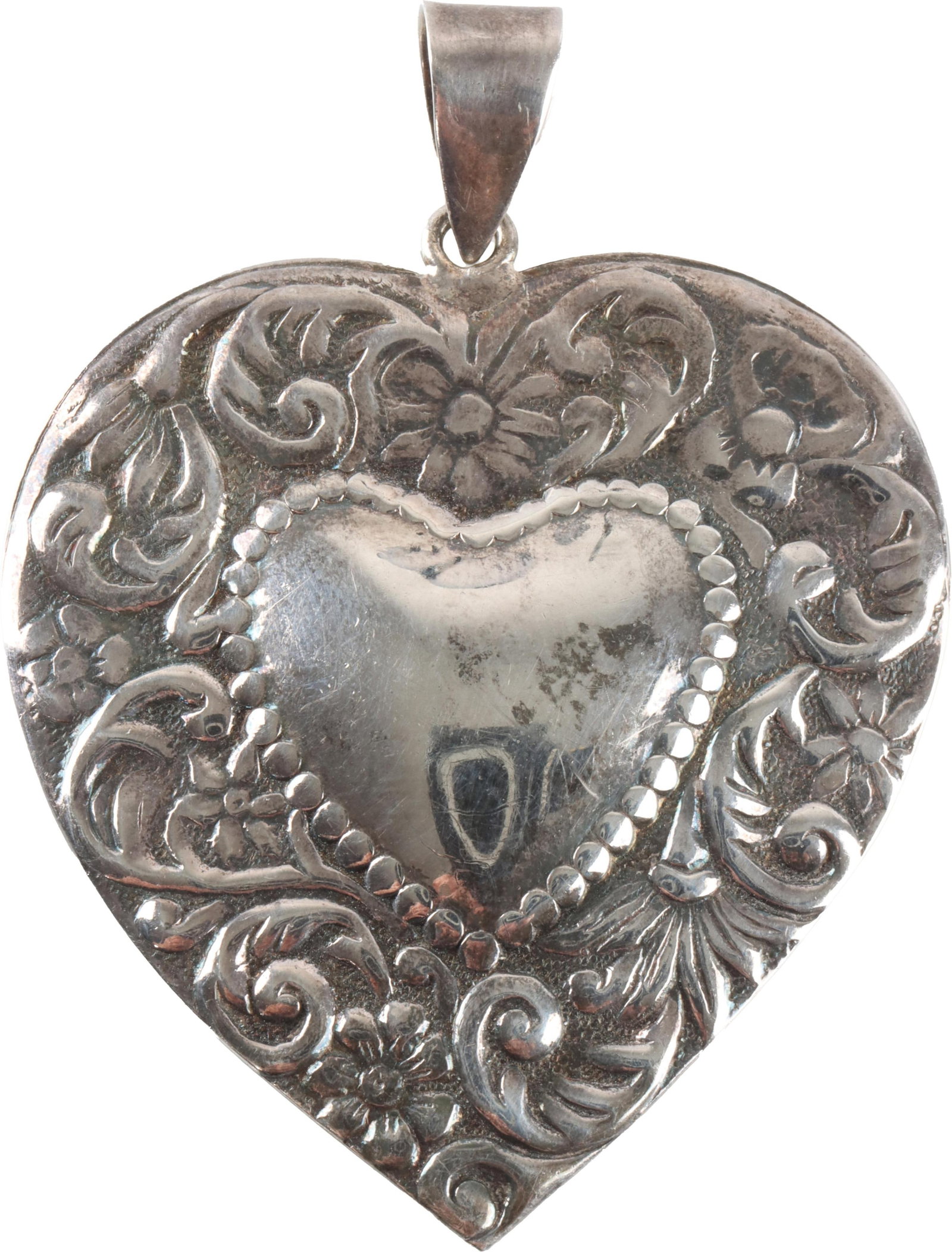 Vintage Sterling Silver Heart Pendant: A heart-shaped, embossed pendant with intricate floral scrollwork design. Stamped 'NF 925' inside of the bail. Measures approximately 1 3/4" x 2"; weighs 11.4 grams. | This lot has a reserve.