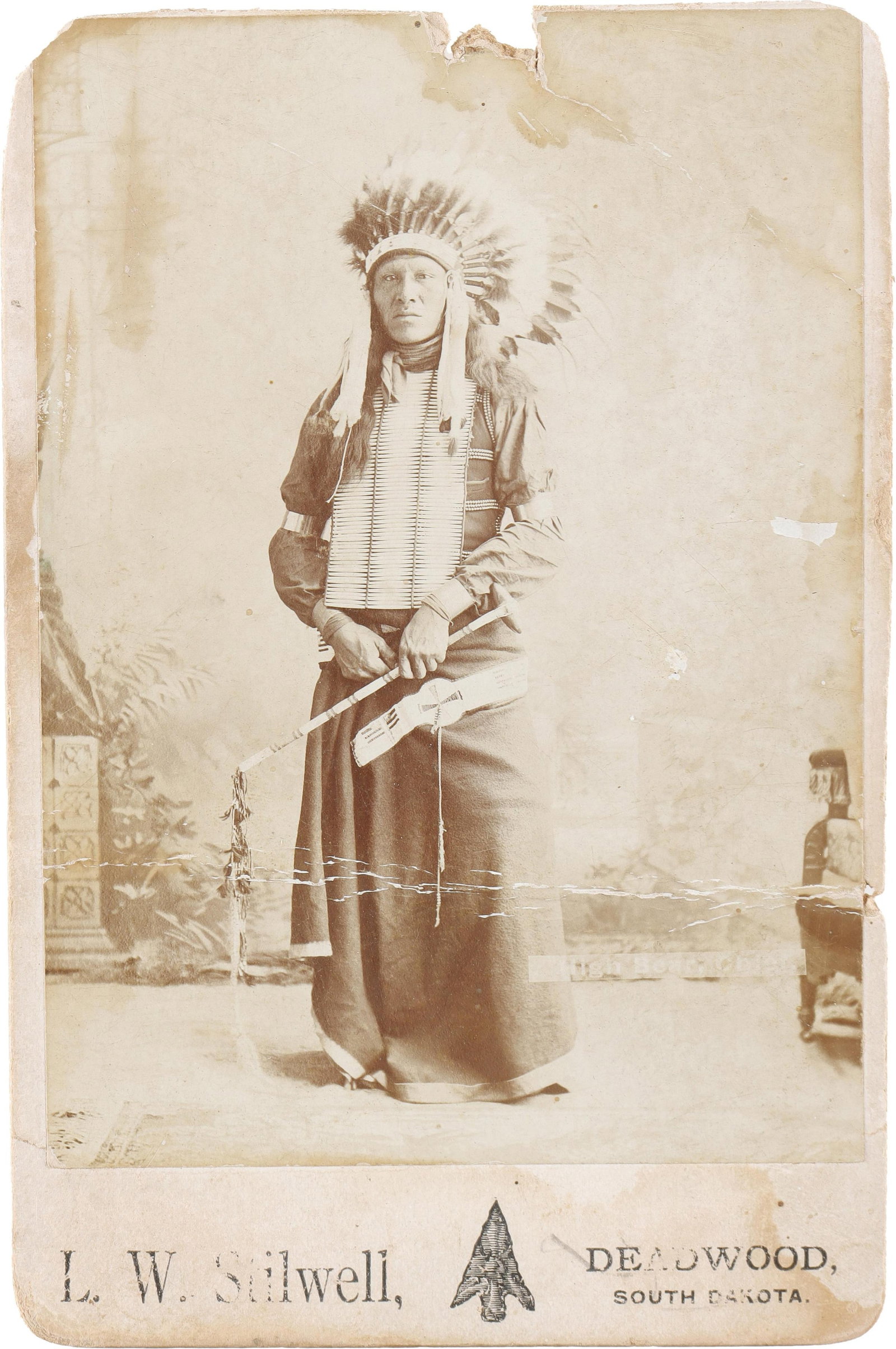 High Bear Cabinet Photo Stillwell Deadwood: An advertising cabinet photo from L. W. Stillwell, depicting Chief High Bear of the Brule Lakota. High Bear was frequently photographed, though this is a rarer variant of one portrait sitting where he