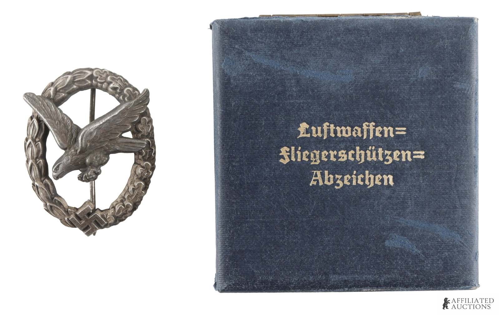 Luftwaffe Gunner Badge WWII German Reich: Luftwaffe gunner badge by C.E. Junker. Comes in blue fitted case with Luftwaffe Fliegerschutzen Abzeichen title on top. Measures 2 inches. | This lot has a reserve.