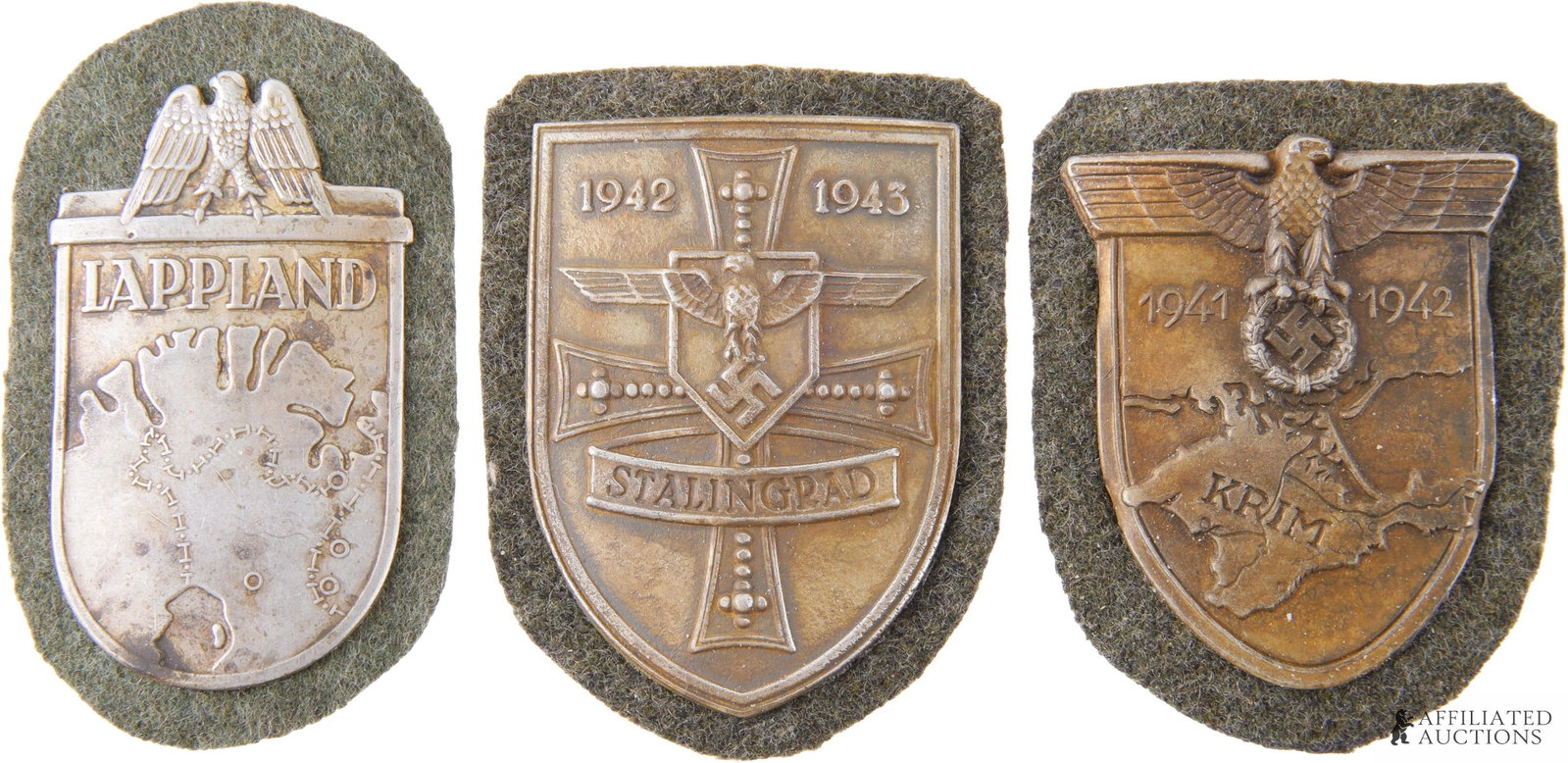 Campaign Shields WWII German Third Reich Lot of 3: A collection of three (3) campaign shields for the uniforms of the German Third Reich. 1) Lappland. 2) Stalingrad. 3) Krim. All on green cloth patch background.
