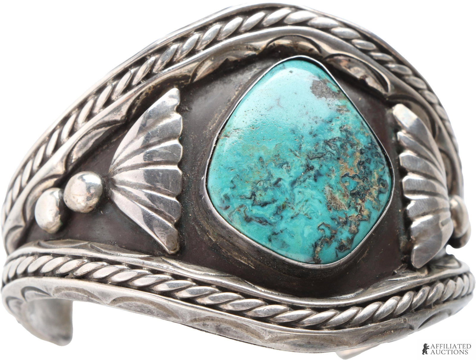 Southwest Native American Turquoise Cuff: A Southwest Native American Navajo cuff with large central turquoise stone, flanked by fan-and-Navajo pearl motifs. Weighs 119 grams. Measures 8.5 inches around with the gap. | This lot has a reserve.