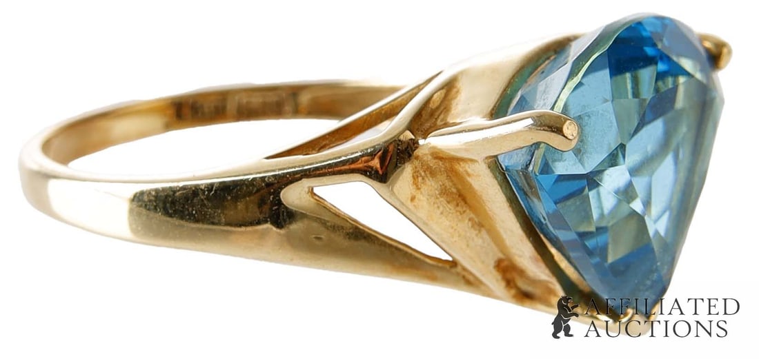 Trillion Cut Blue Topaz 10K Gold Ring: A trillion cut blue topaz in a 10K gold basket setting. Topaz is approximately 6 carats. Size 7. Weighs 5 grams. | This lot has a reserve.