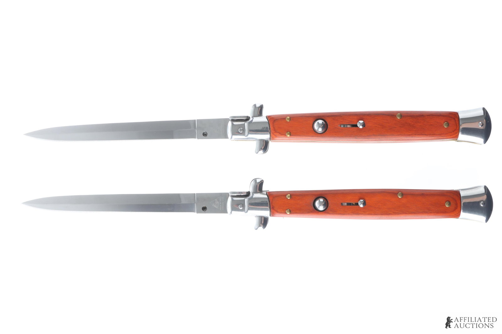 2 AKC 13 Inch Italian Switchblade Knife Lot: Lot of two AKC Italian-made switchblades. Knives measure 13 inches open, 7 inches closed. Blades are of stainless steel construction. Grips are of stained wood construction.