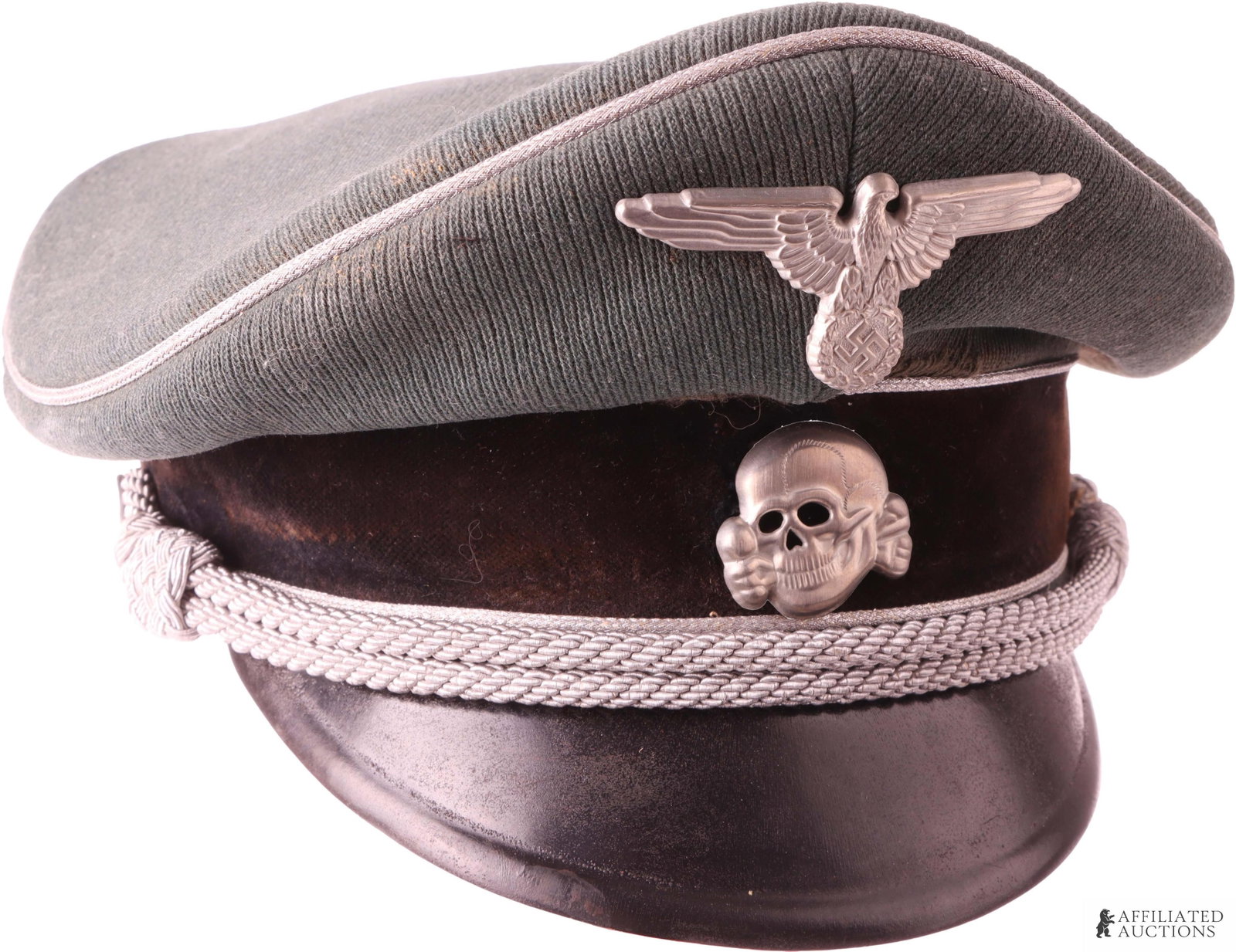Waffen SS officer Visor WWII German: Gabardine construction. Exterior features reichsadler and totenkopf pins, bullion chin strap, and vulcanized fiber visor. Rayon liner. Maker mark under cellophane sweat shield. Interior diameter measu
