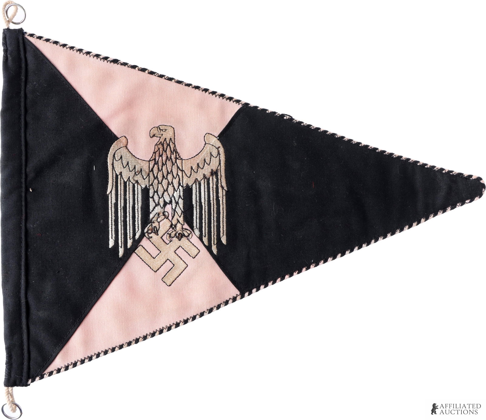 Panzer Commander Pennant WWII German: Double sided cloth construction. Features eagle clutching swastika on pink and black pattern. Alternating piping on border. It measures 13 X 10 inches approximately. | This lot has a reserve.