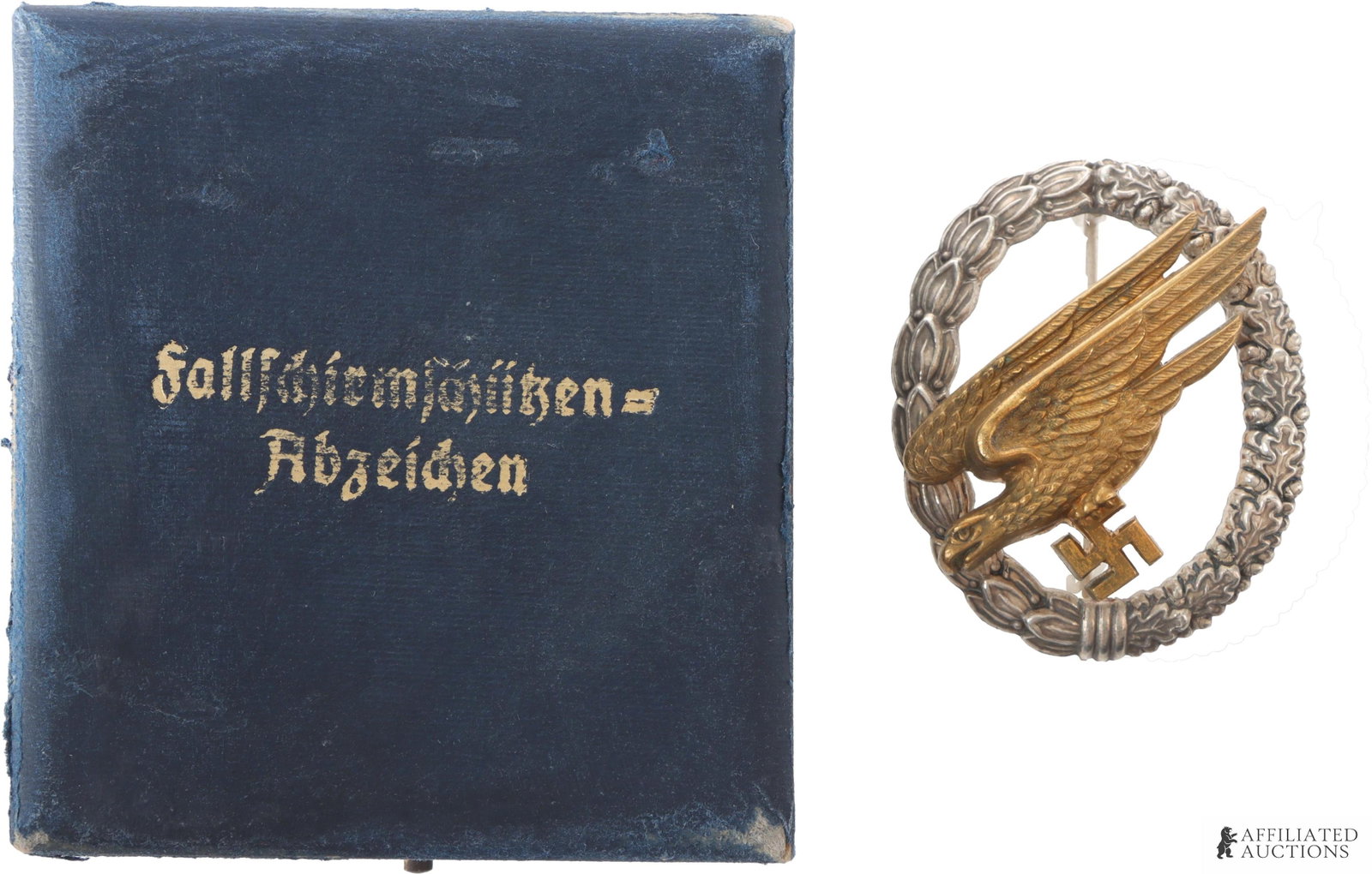 Cased Luftwaffe Paratrooper Badge WWII German: WWII German Luftwaffe pilot badge. Diving reichsadler surrounded by oak leaf wreath. Badge is C.E. Juncker marked. Bronze eagle riveted to silver plated zinc wreath. It measures 52.5mm x 43mm. | This 