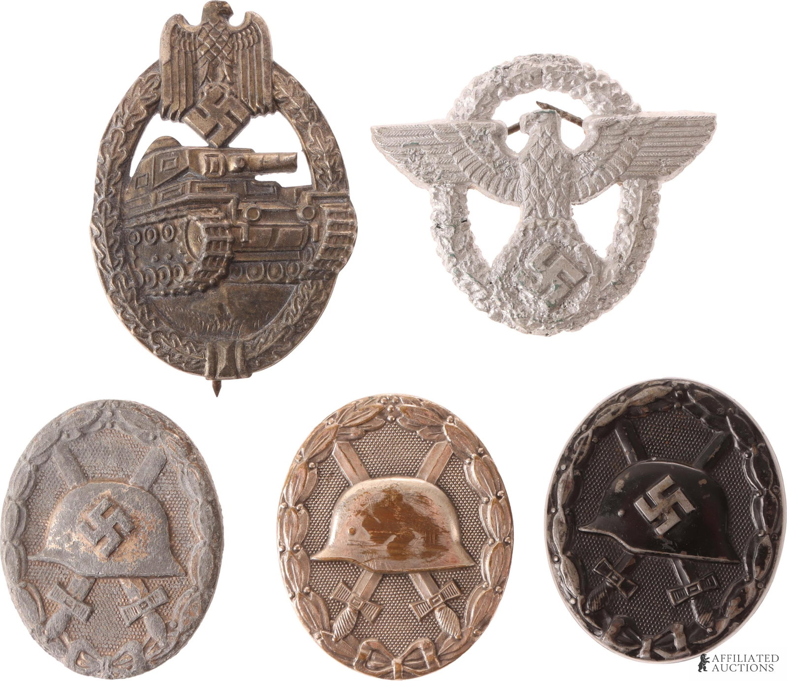 Lot of 5 WWII German Badges Wound Tank Police: Lot features a police cap badge, one bronze tank badge stamped R. S, 3 wound badges. Measurements range 1.75 - 2.25 inches.