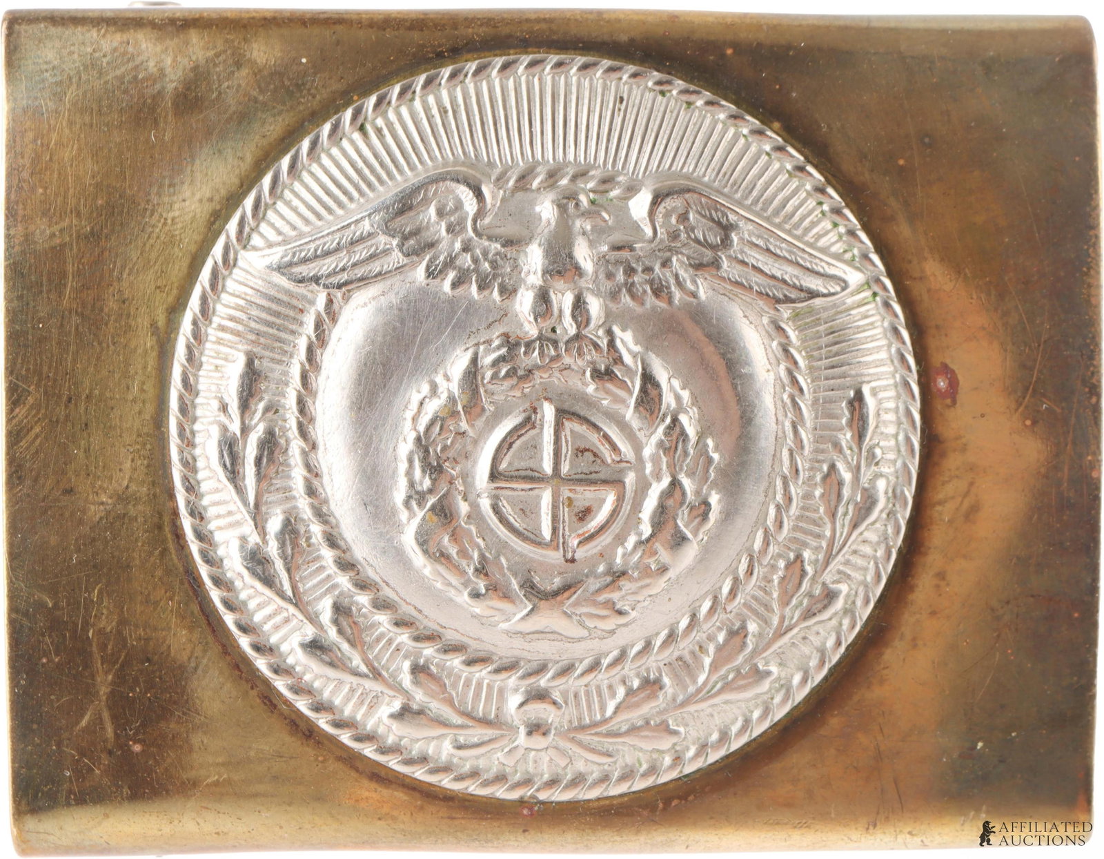 Sturmabteilung Sonnenrad Belt Buckle WWII German: Sturmabteilung (SA) belt buckle from the German Third Reich. Shows an eagle clutching a wreathed sonnenrad-style spinning swastika. Multipiece construction. Gold tone aluminum. 2.5x1.75 inches.
