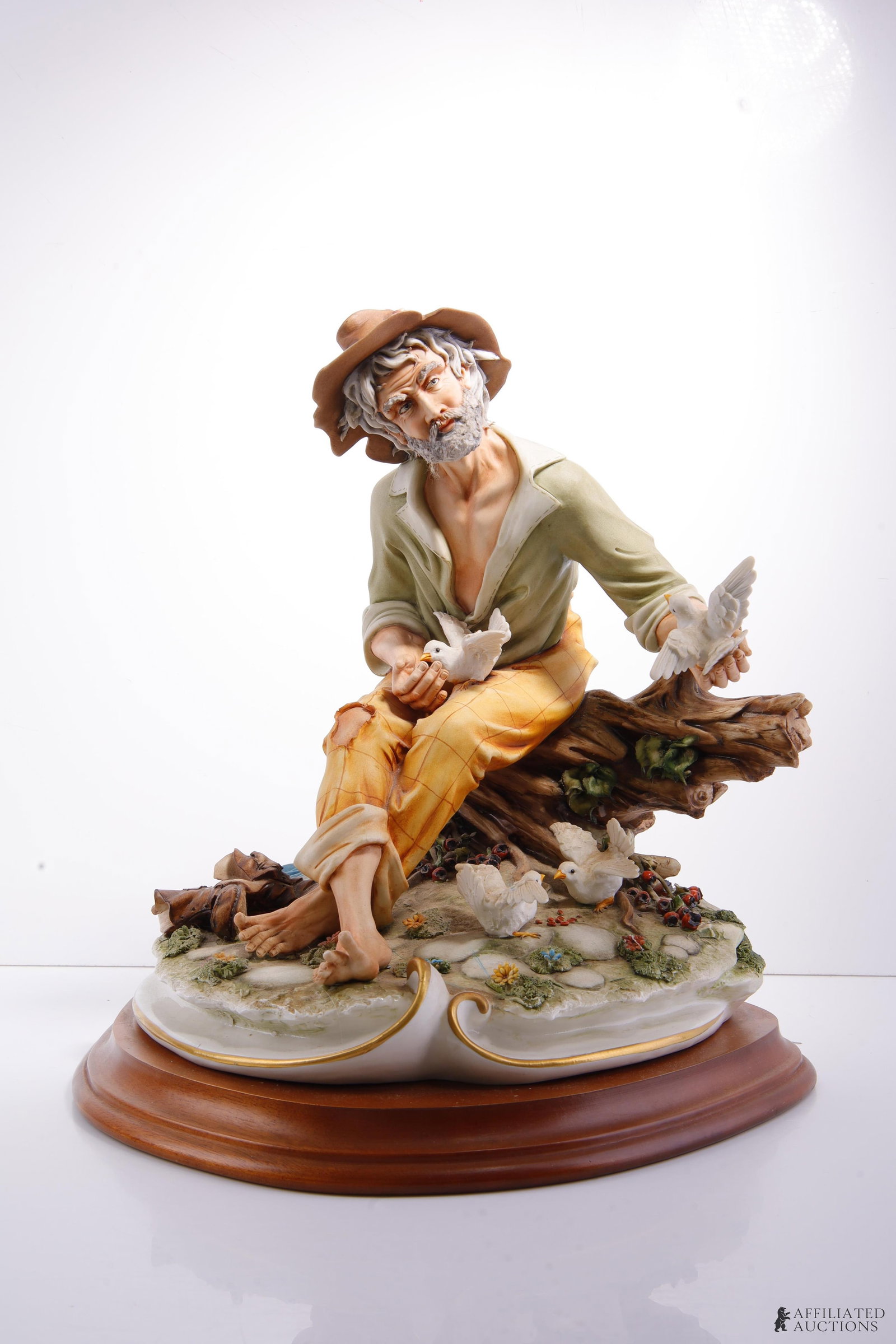 Capodimonte Porcelain Cortese Tramp Feeding Birds: Italian Capodimonte porcelain sculpture by Germano Cortese. Signed on reverse and marked "Made in Italy 73" with crown over "N." Set on wood plinth. Height 15 inches. Base approx. 13x15 inches. Weight