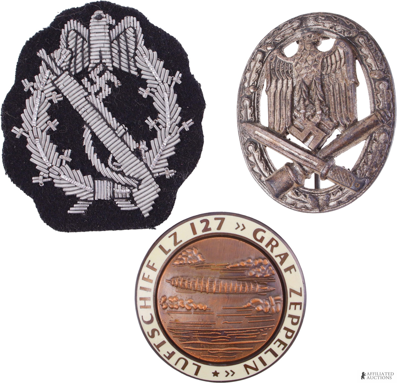 WWII Military Badge Lot of 3 German Third Reich: A lot of three WWII German military badges. Includes 1) a 1 7/8 inch Luftschiff LZ 127 Graf Zeppelin badge marked 'FLL' on reverse and weighing 39.2 grams, 2) a General Assault badge, unmarked, measur
