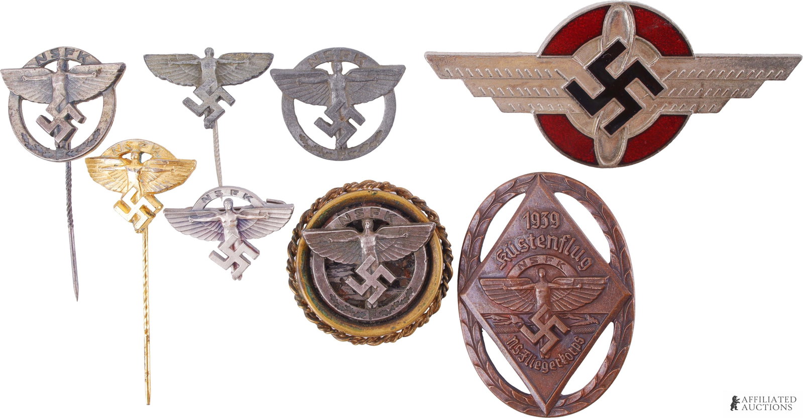 Lot of 5 WWII German NSFK Pins 1939 Glider Pilot: Lot contains five (5) various NSFK insignia pins, one (1) C-level glider pilot pin, Enameled NSFK insignia, 1939 NSFK "Kustanflug" Participant pin. Pins range from 7cm x 3cm to 3.5cm x 4.5cm.