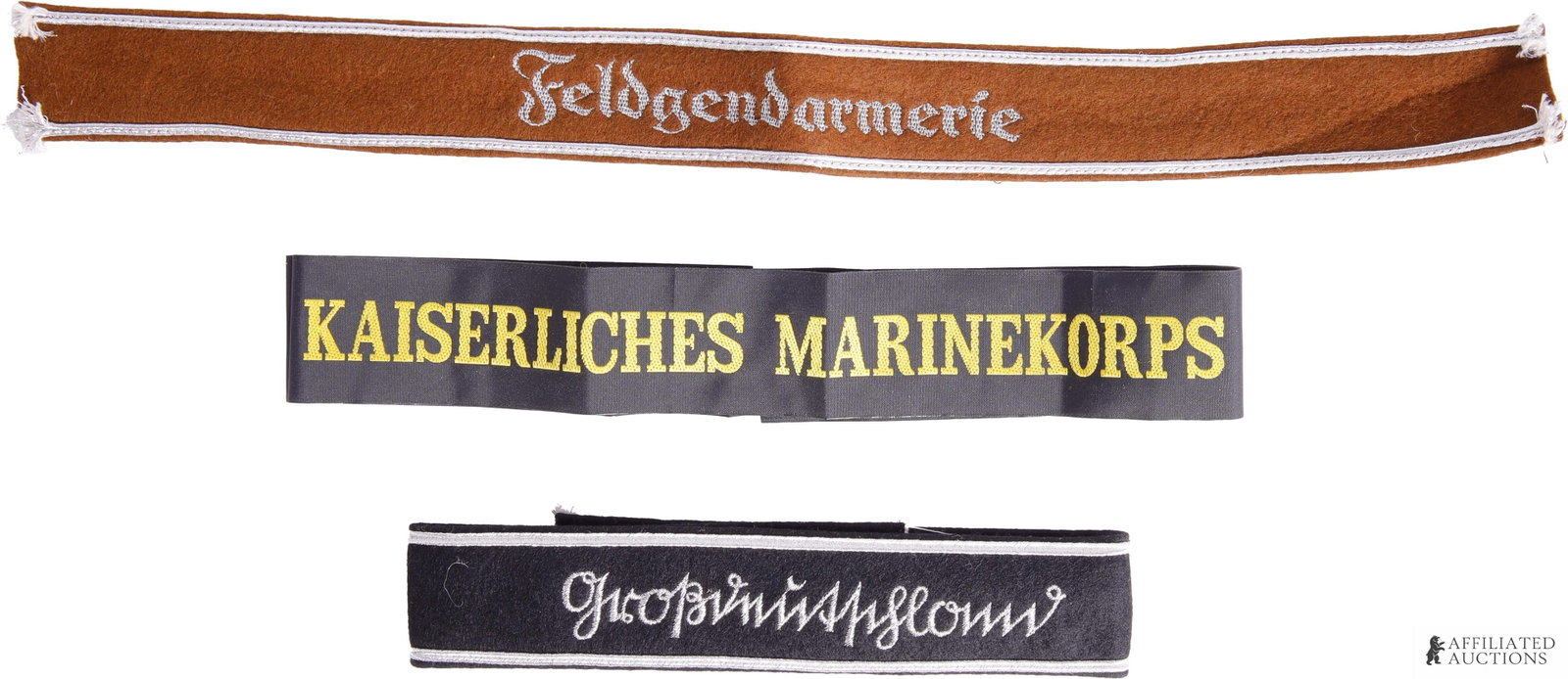 Military Cap Tally & Cuff Titles WWII German Reich: A lot containing two (2) WWII German cuff titles and one (1) hat band. Includes 1) a Kaiserliches Marinekorps cap tally measuring 42 inches, 2) a brown felt Feldgendarmerie cuff title with aluminum bu
