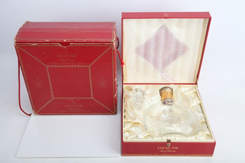 REMY MARTIN LOUIS XIII COGNAC CRYSTAL BOTTLE: Empty cognac decanter comes boxed within a satin- lined presentation case and includes: original booklet, Fleur-De-Lis crystal stopper, and original outer cardboard box. Bottle shows minimal sign of w