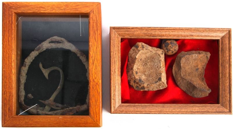 GROUPING OF CIVIL WAR DUG RELICS: Items include a CSA iron stirrup, Enfield musket trigger guard, projectile shrapnel fragments, and one grape shot, contained in two shadow boxes.