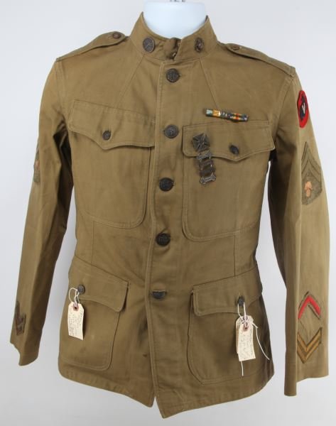 WWI USMC CORPORAL 5TH BIRGADE ARTIFICER TUNIC: Tunic holds the ranking of Corporal of Ordnance, along with two gold chevron, and one red chevron. Decorated with Rifle Marksman Carbine and Sub Machine badges. WWI Service medal, and WWI Victory meda