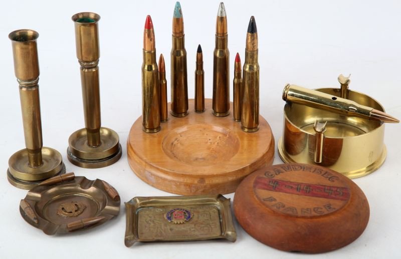 TRENCH ART COLLECTION WWI TO VIETNAM GOOD VARIETY: Includes WWI Chateau Thiery ashtray, Verdun ashtray, 1942 dated shell ashtray, Caudebec 4-14-45 wood ashtray, 1945 shell candlesticks, and a Vietnam bullet trinket dish.