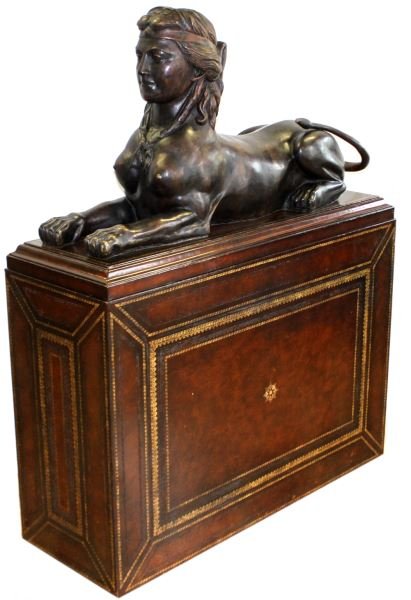 MAITLAND-SMITH LARGE BRONZE SPHINX WITH BASE: Maitland-Smith bronze sphinx measures 43 by 23 by 14 on large wood and leather decorative plinth measuring 46.5 by 55.5 by 16.5 inches. Label on base and removable bronze topper marked “Maitland-Smi