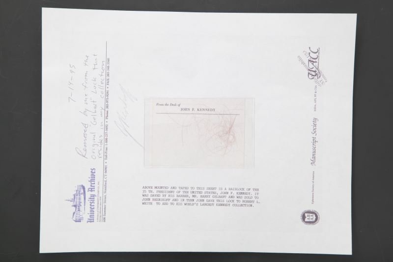 STRANDS OF HAIR FROM THE HEAD OF JOHN F KENNEDY: Strands of hair from John F. Kennedy attached to a piece of paper with information regarding the hair. Overall in very good condition.
