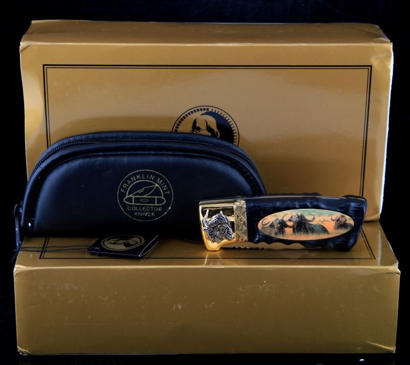 LOT OF 2 FRANKLIN MINT WILDLIFE FOLDING KNIVES: This lot contains two Franklin Mint Wildlife folding knives, one commemorating "Water Buffalo" and the other "Lions." Both knives have stainless steel locking blade with accents of 24 kt gold at the e