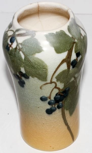 SARA SAX SIGNED ROOKWOOD 1904 VASE WITH GRAPES: A signed vase by Sara Sax. dated with Rookwood logo, flames and Roman Numerals "IV". Six inches tall. Motif is grapes with leaves and vine. Heavy clear glaze show crazing throughout, and there are two