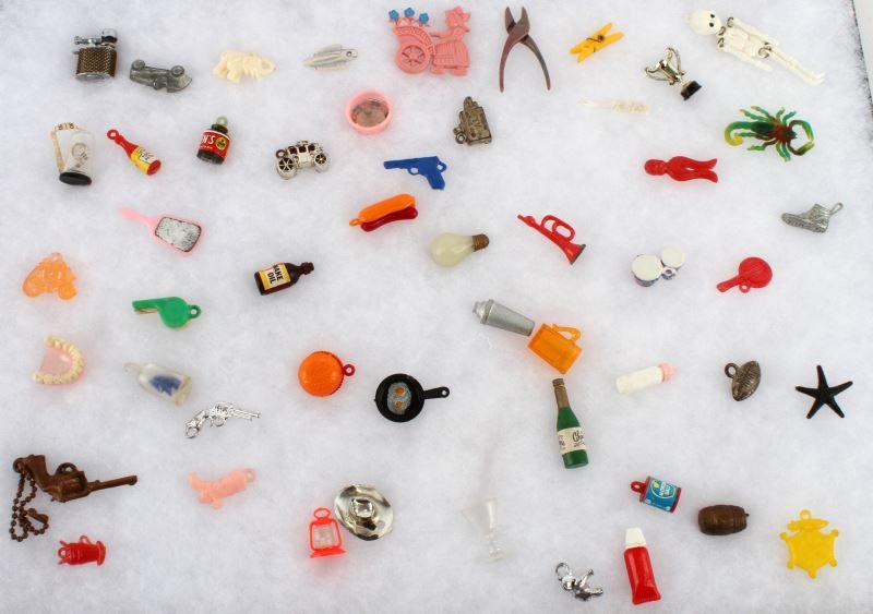 VINTAGE LOT OF GUMBALL MACHINE/CRACKER JACK TOYS: This lot includes a large variety of 52 gumball machine and cracker jack toys, some meant for charm bracelets. Figures include a hamburger, champagne, hotdog, football, Morton salt, whistle, skeleton,