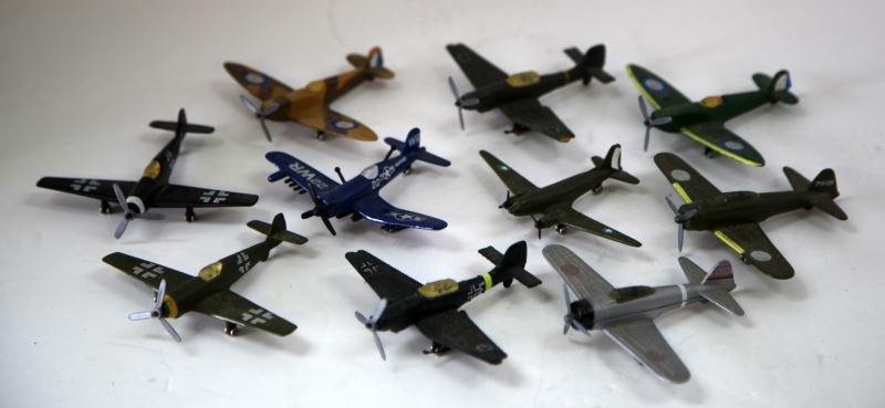 TEN DIE CAST MINIATURE WWII METAL TOY PLANES: This collectors lot includes planes like the Spitfire, ME 109, JU-87, Zero, FAU-4, and the Douglas DC-3. Overall the miniature metal planes are in very good condition.