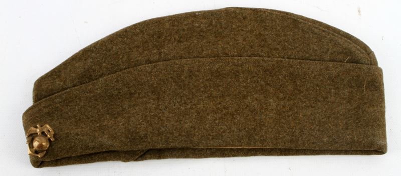 WWI UNITED STATES MARINE CORPS GARRISON CAP: Garrison cap contains period EGA. Inside of cap is marked "6718" Two small stains are present to the top of the cap, some mothing is present; overall in very good condition.